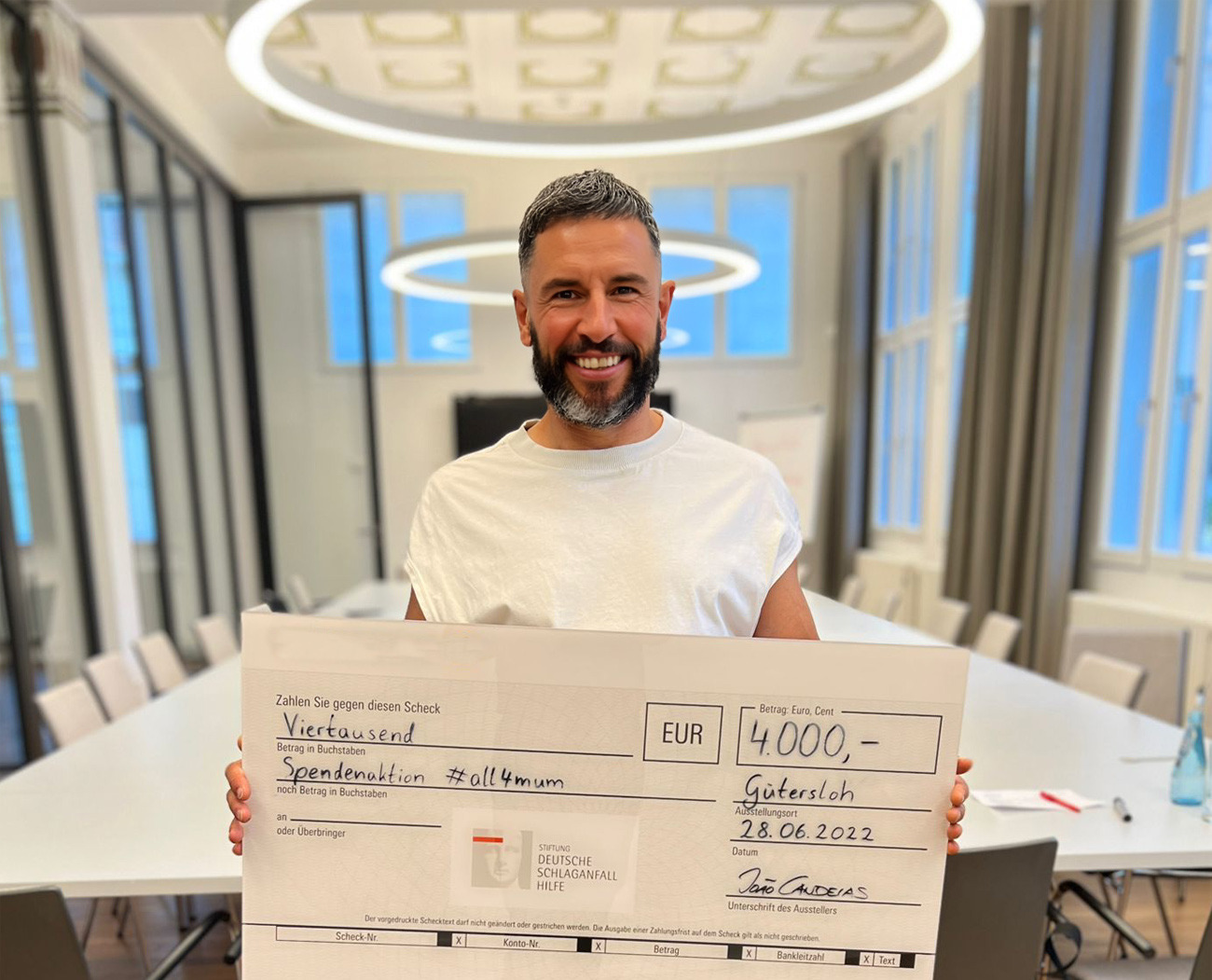 Joao mit Spendenscheck über 4.000 Euro