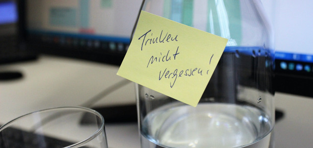 Ein PostIt auf dem Bildschirm auf dem geschrieben steht: Trinken nicht vergessen.